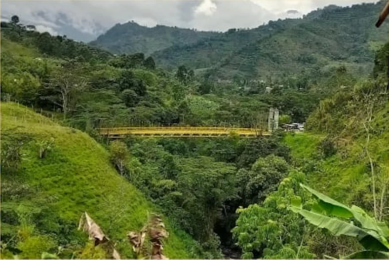 Paisaje montañoso de Antioquia atravesado por puente amarillo